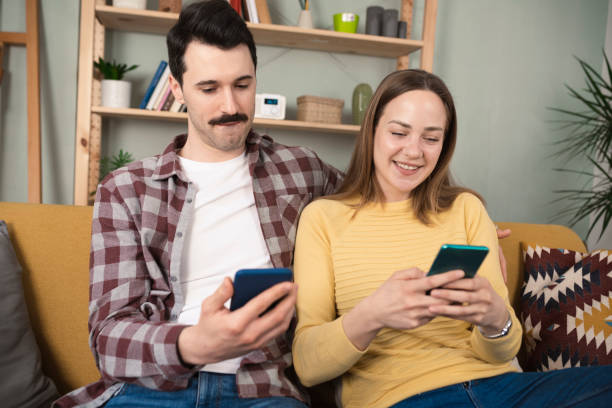 istock Happy young couple using smartphone together 1389202655