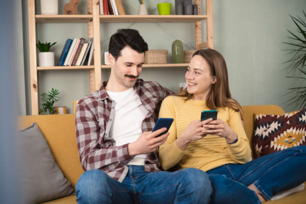 istock Happy couple using smartphone at home 1389202656