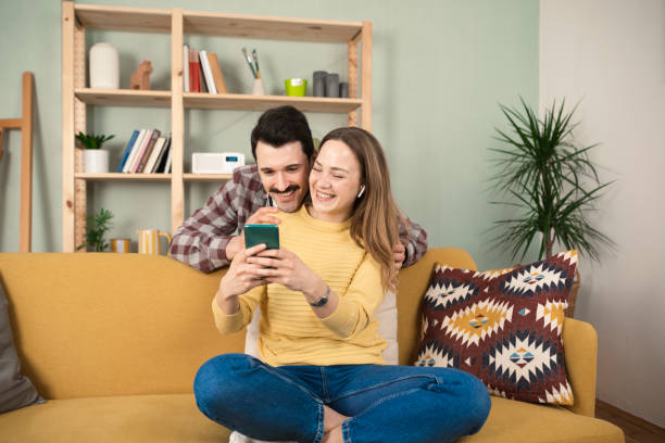 istock Cheerful couple using mobile phone 1389202689