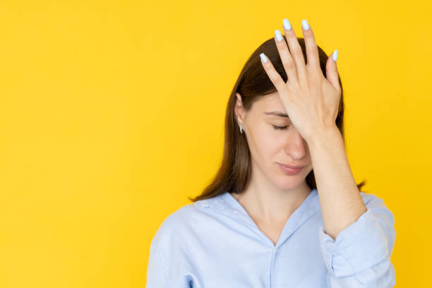 facepalm gesture shocked woman epic fail pretty Facepalm gesture. Shocked woman. Epic fail. Pretty expressive lady holding hand on forehead isolated yellow copy space. head in hands stock pictures, royalty-free photos & images