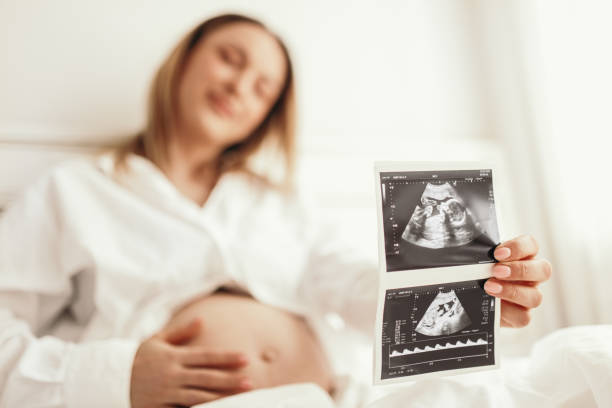 istock Blurred mother showing baby sonogram 1389206445