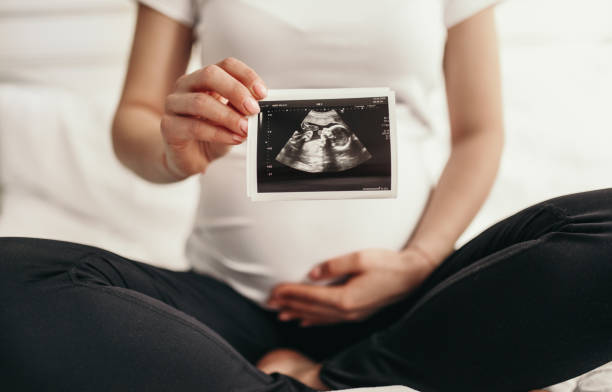 istock Pregnant woman with sonogram image 1389206456