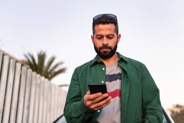 istock young man with beard consulting mobile phone 1389207024