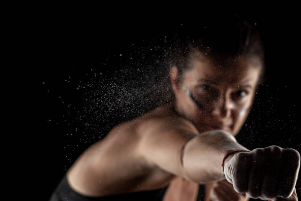 istock Kickboxer kirl with magnesium powder on her hands, punching with dust visible 1389210345