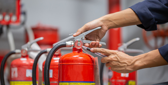 Engineer are checking and inspection a fire extinguishers tank in the fire control room for safety training and fire prevention.