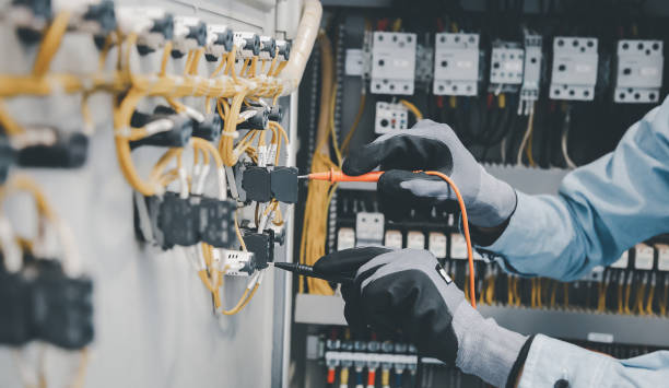 istock Electrical engineers test electrical installations and wiring on protective relays, measuring them with a multimeter. 1389214615
