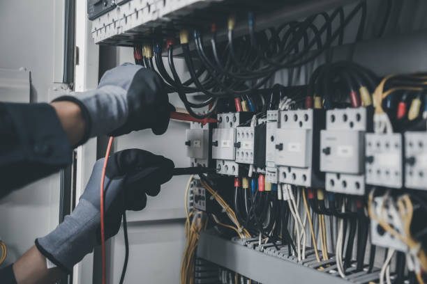 istock Electrician engineer tests electrical installations and wires on relay protection system. Adjustment of scheme of automation and control of electrical equipment. 1389214942