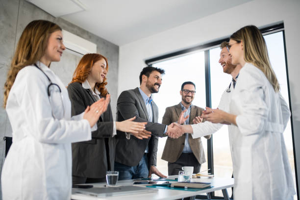 Business people having a meeting with doctors in the office and shaking hands. stock photo