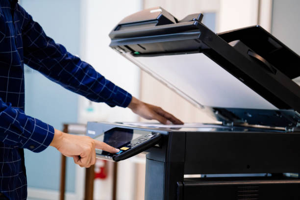 istock Businessmen press button on the panel for using photocopier or printer for printout and scanning document paper at office. 1389216041