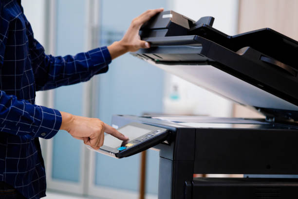 istock Businessmen press button on the panel for using photocopier or printer for printout and scanning document paper at office. 1389216047