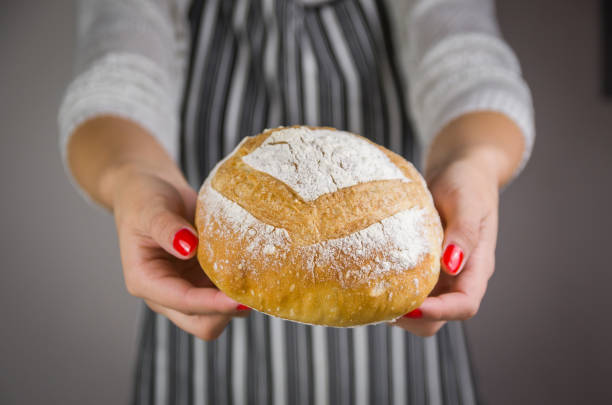 istock Beautiful Sourdough bread being held by woman's hands 1389232595
