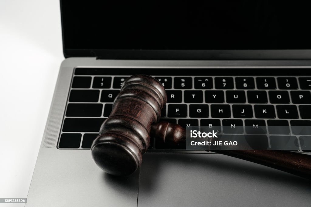 Computer and hammer on white background board Legal System Stock Photo