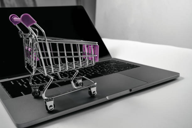 istock Computer and shopping cart on white background board 1389235448