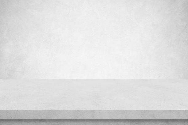 istock Empty white cement table over white cement concrete wall background, banner, table top, shelf, counter design for product display montage 1389243742