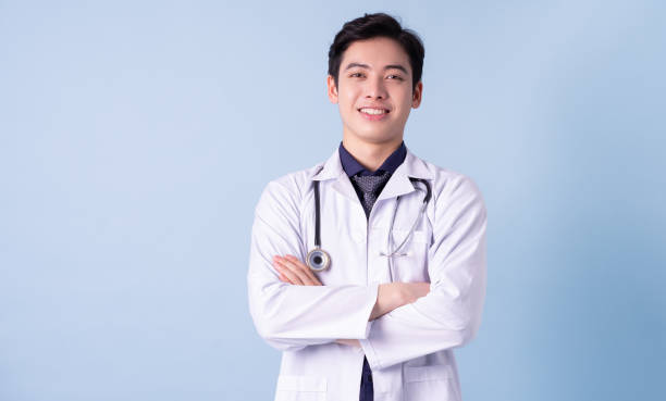 retrato de un joven médico asiático sobre fondo azul - filipino ethnicity asian ethnicity men male fotografías e imágenes de stock