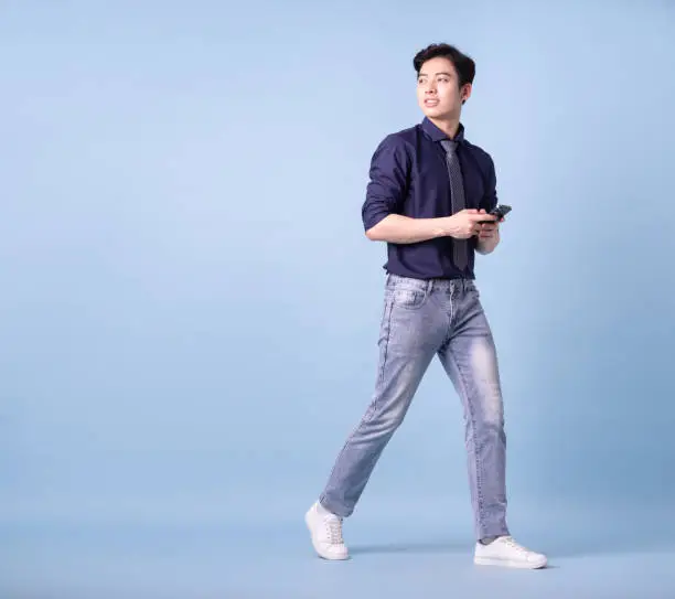 Photo of Full length image of young Asian businessman on blue background