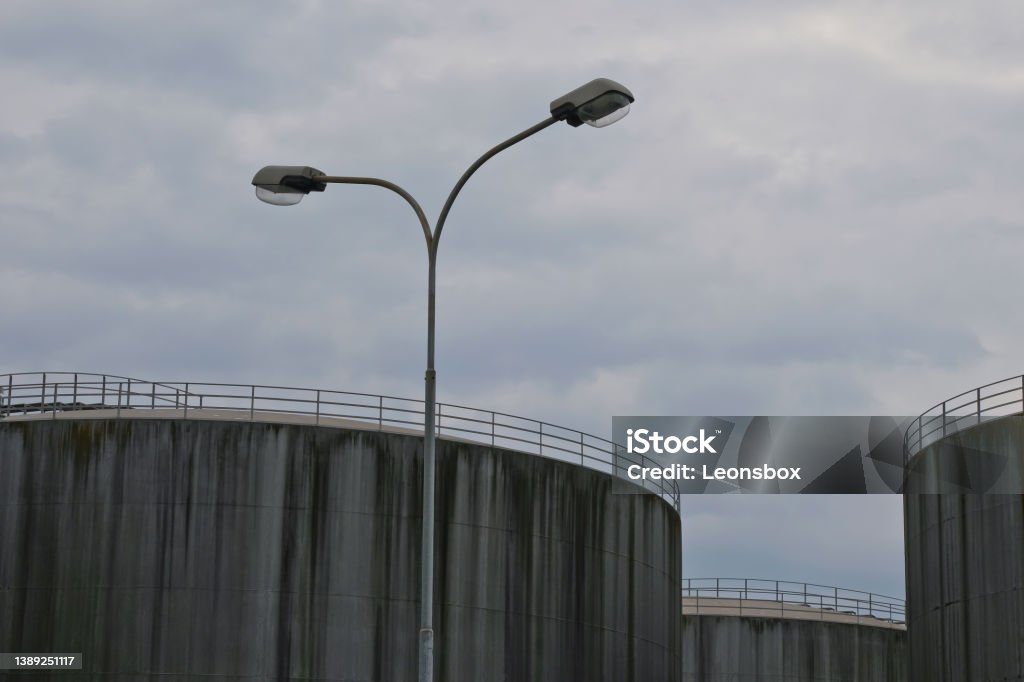 Concreted storage silos for fossil fuels Grim detail shot of storage silos in an industrial area. Concept for the upcoming bleak situation of fuel shortage. Crisis Stock Photo