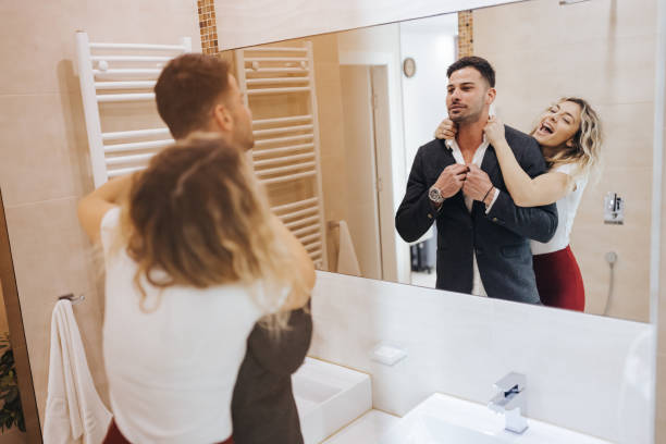 istock Beautiful young couple looking at bathroom mirror while getting ready to go out 1389255248