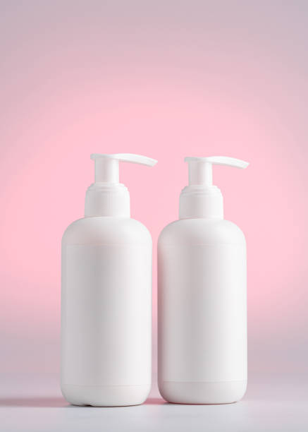 istock Blank white Bottles for Shampoo, Mock up packaging on a Pink light background, Packaging for Shampoo without logo and label 1389257480