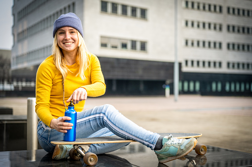young blonde girl using a water bottle to drink, sustainable and ecological life concept, zeto waste and without plastic