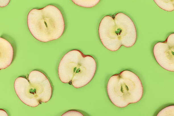 istock Apple slices on green background 1389271469