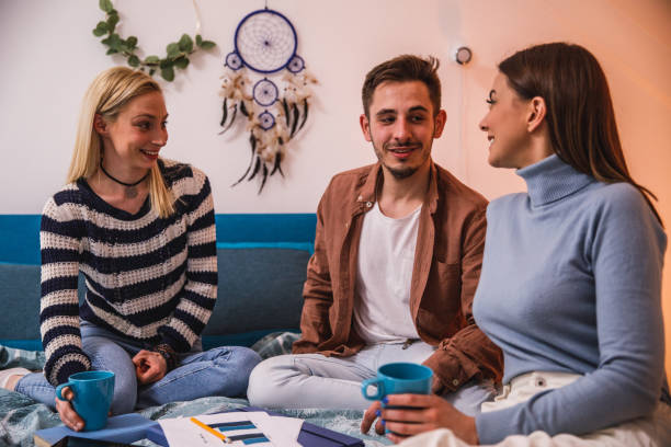 istock Three roommates sitting on bed, chatting and hanging out over coffee 1389274680