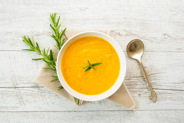 istock Pumpkin soup with linen napkin on light background. 1389275971