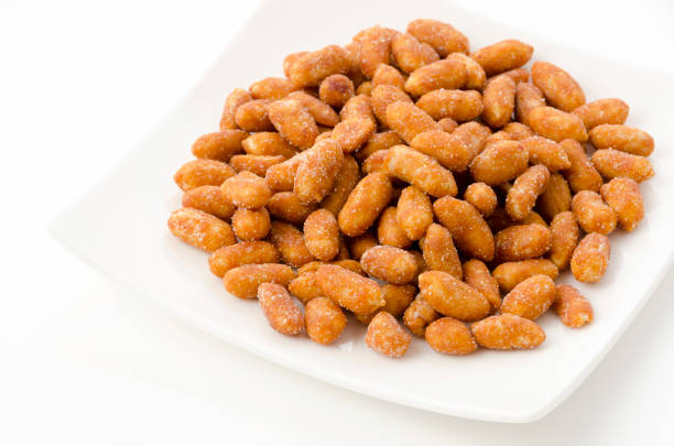 istock Honey roasted peanuts in a white plate on a white background 1389276996