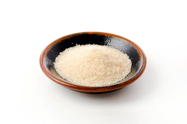 istock San-ontou, Light brown sugar in a black plate on white background 1389277102