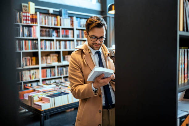 biznesmen w bibliotece - book holding necktie businessman zdjęcia i obrazy z banku zdjęć