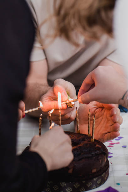 istock Birthday cake : group of friends preparing chocolate cake with candles. Vertical image 1389277448