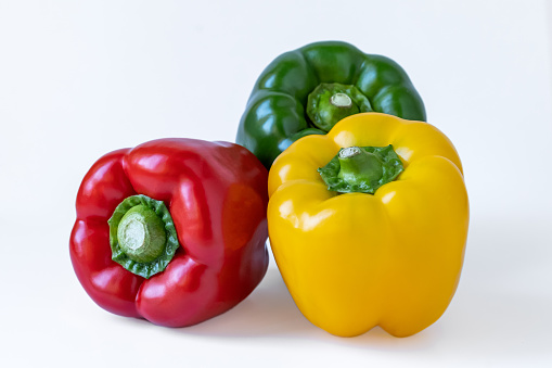 Close-up of tricolor peppers, isolated white background.