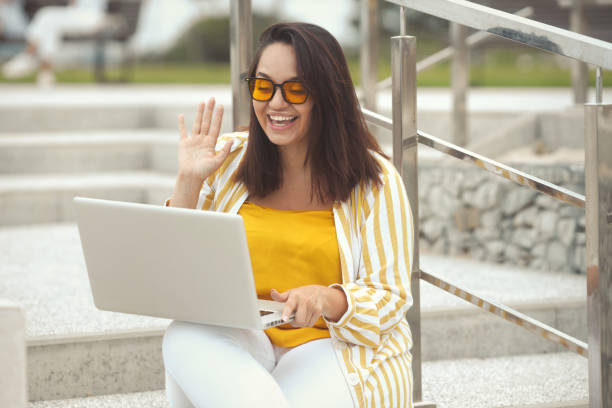 istock Mid adult woman outdoors using laptop 1389281719