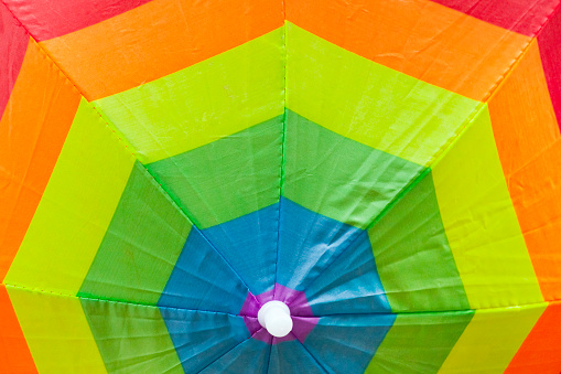 Multi colored open umbrella, full frame view seen from above, concentric circles . Image suitable for background purposes. Copy space on the upper part of the image.