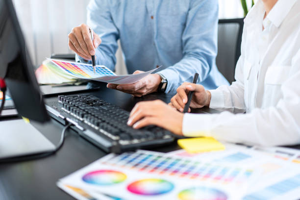 istock Team graphic designer working on document of color chart to brainstorming about new project and using laptop 1389283637