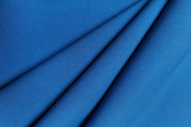 istock Blue crumpled or wavy fabric texture background. Abstract linen cloth soft waves. Gabardine wool fabric. Merino yarn. Smooth elegant luxury cloth texture. Concept for banner or advertisement 1389284180