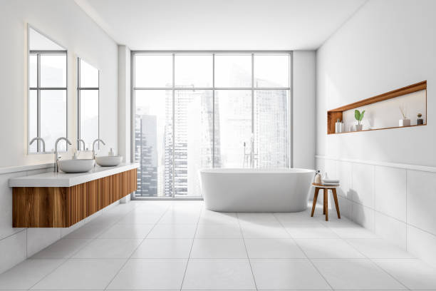 istock Bright bathroom interior with bathtub, concrete tile floor, panoramic window 1389285979