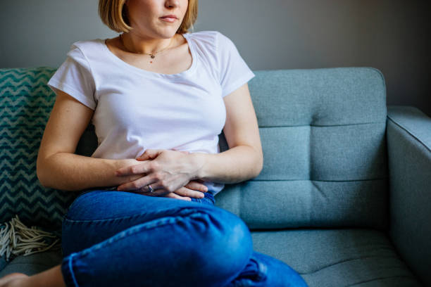 istock Woman experiencing stomach pain while lying on the sofa at home 1389291985