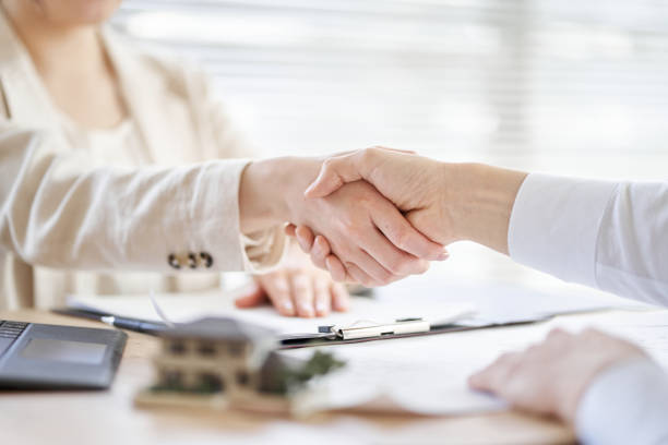 Asian real estate agent who closes a business and shakes hands stock photo