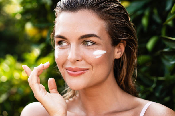 Beautiful woman with moisturizing cream under her eyes Outdoor portrait of beautiful woman with moisturizing cream under her eyes suntan lotion stock pictures, royalty-free photos & images
