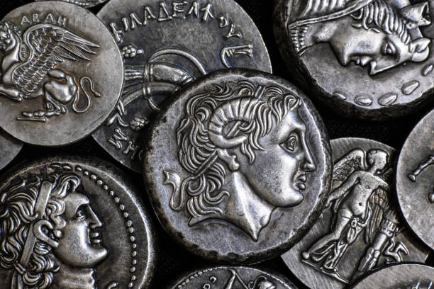 Coin with Alexander the Great portrait and Ancient Greek coins Ancient Greek coin with Alexander the Great portrait, pile of silver tetradrachm coins. Top view of old rare money. Concept of Greece, valuable coins collection, ancient history and treasure. ancient history stock pictures, royalty-free photos & images