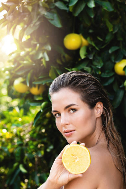 istock Beautiful woman with smooth skin with a lemon fruit in her hands 1389296475