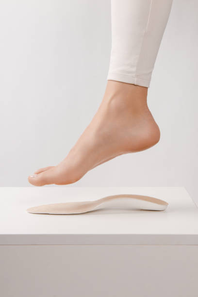 medical insoles. isolated orthopedic insoles on a white background. treatment and prevention of flat feet and foot diseases. foot care. insole cutaway layers. leg hanging over the insole - plattfot bildbanksfoton och bilder