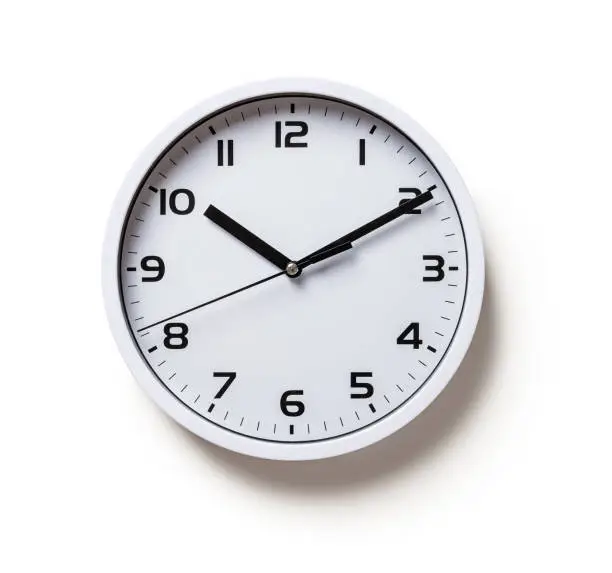 Photo of Wall clock isolated on a white background. Round white clock with black hands cutout. Ten minutes past ten. Time control, time measuring, hour and minutes concepts.