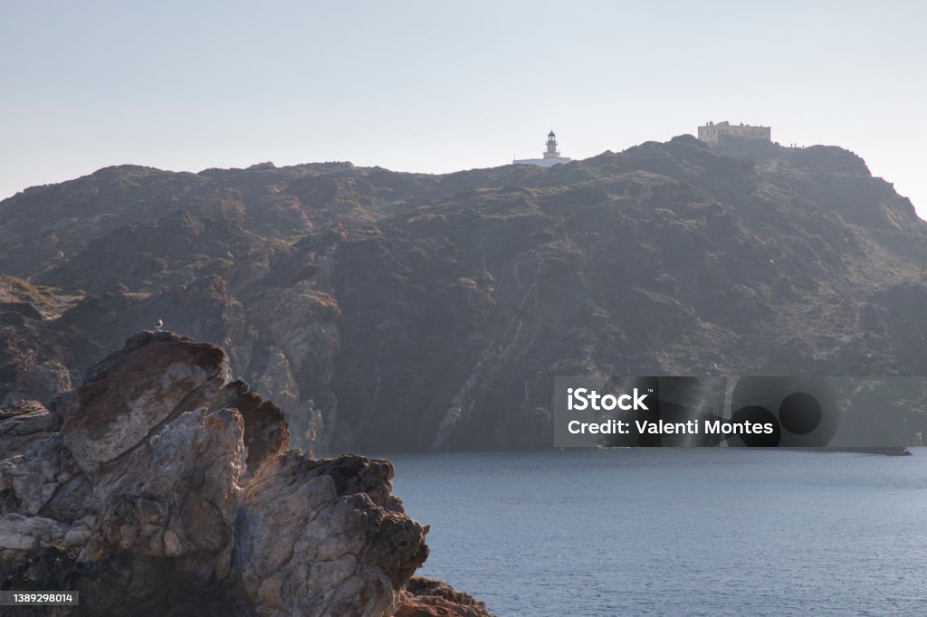 Cap de Creus landscape Seascape showing a building and a lighthouse over a rocky coast and Mediterranean Sea in Cap de Creus Cape in Costa Brava in Catalonia Adventure Stock Photo