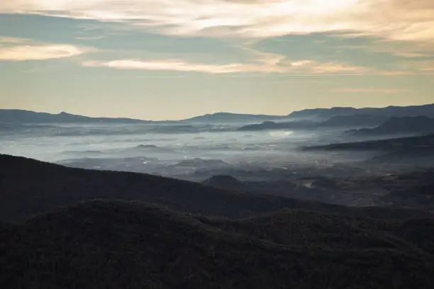 Misty landscape showing a valley and some mountains under a cloudy sky in Santa Maria de Besora in Catalonia