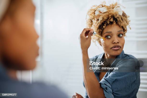 Morning Routine Woman Applying Face Serum Around Her Eyes Stock Photo - Download Image Now