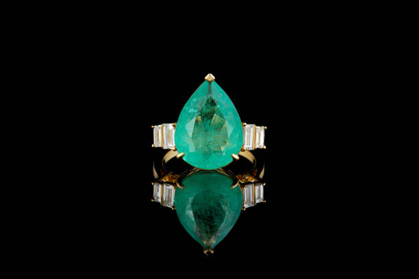 istock beautiful gold ring with emerald and diamonds on a black background 1389302587