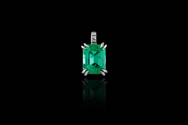 Beautiful pendant with an emerald and a diamond with a chain on a black background