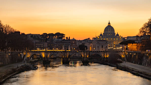 St. Angelo Bridge and St. Peter's Basilica at Sunset stock photo
